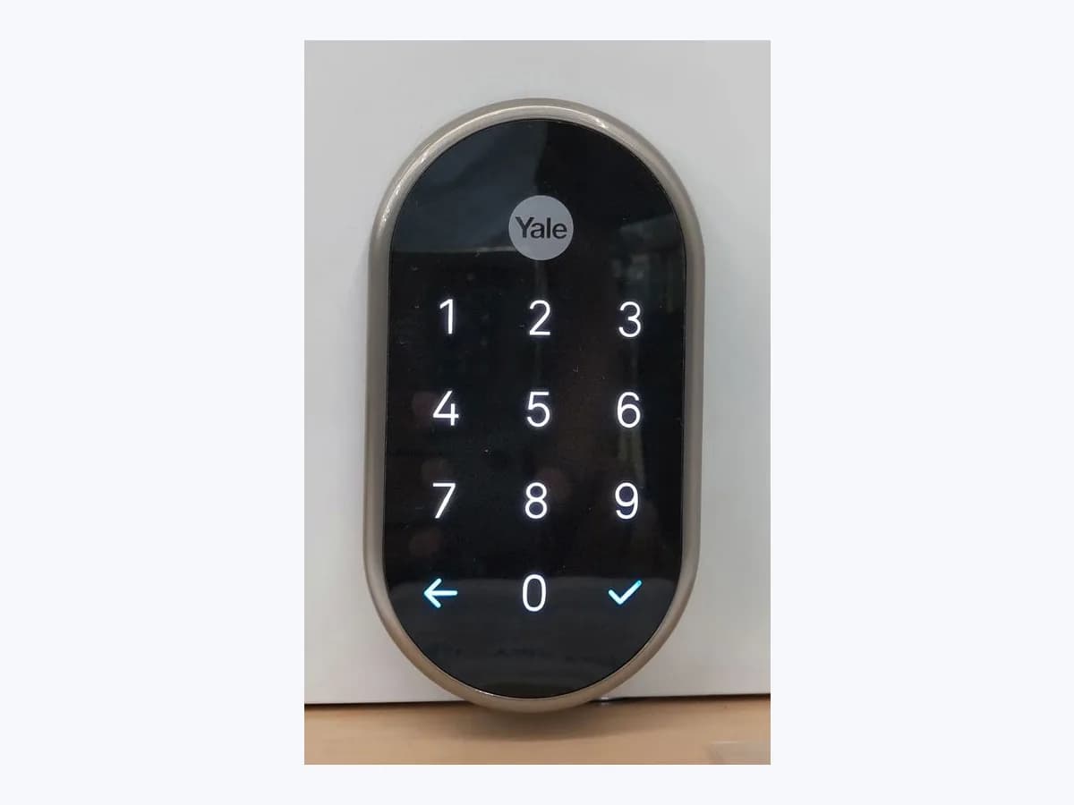 Nest x Yale smart lock with illuminated touch keypad mounted on a white door panel