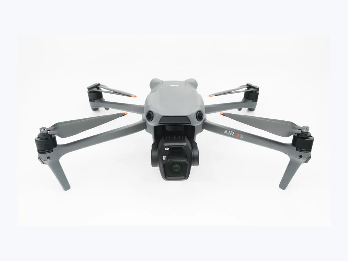 Unfolded grey DJI Air 3S quadcopter drone with four propellers and front dual-camera gimbal on a plain white background