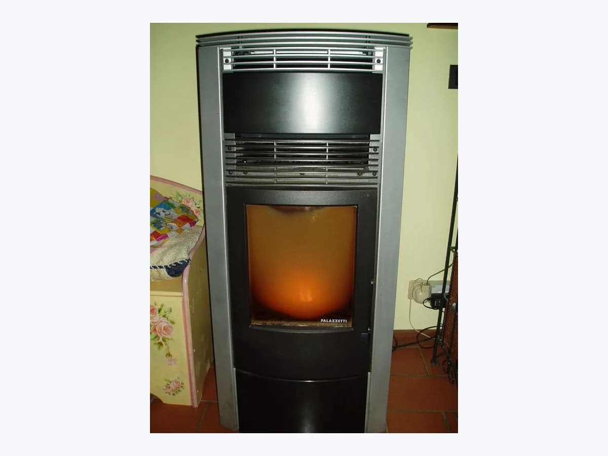 Freestanding pellet stove with glass door and a lit flame