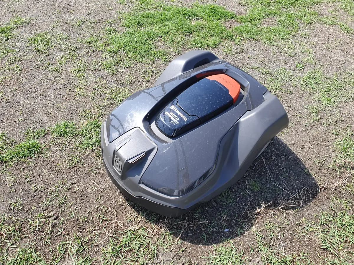 Grey and orange Husqvarna Automower 430X robotic lawn mower on a lawn