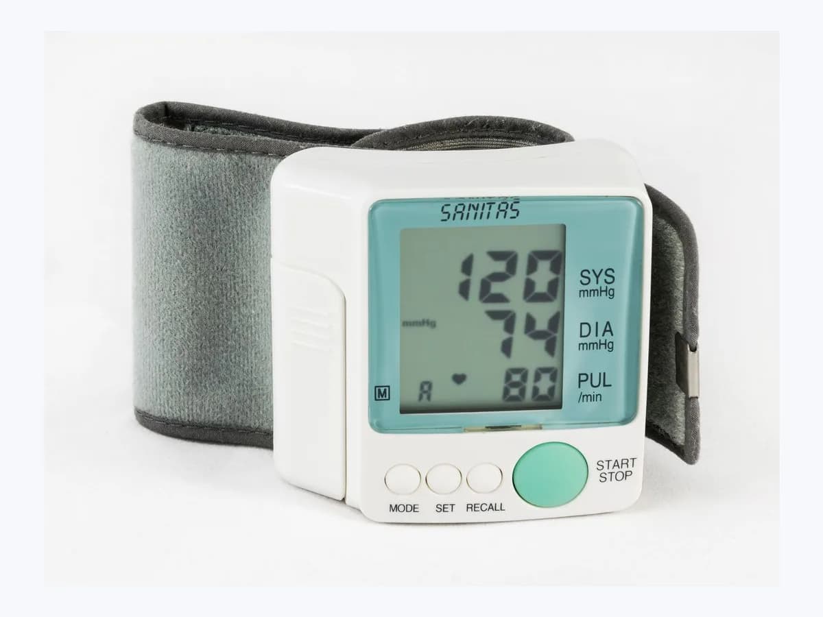 White electronic wrist blood pressure monitor with its cuff on a plain white background